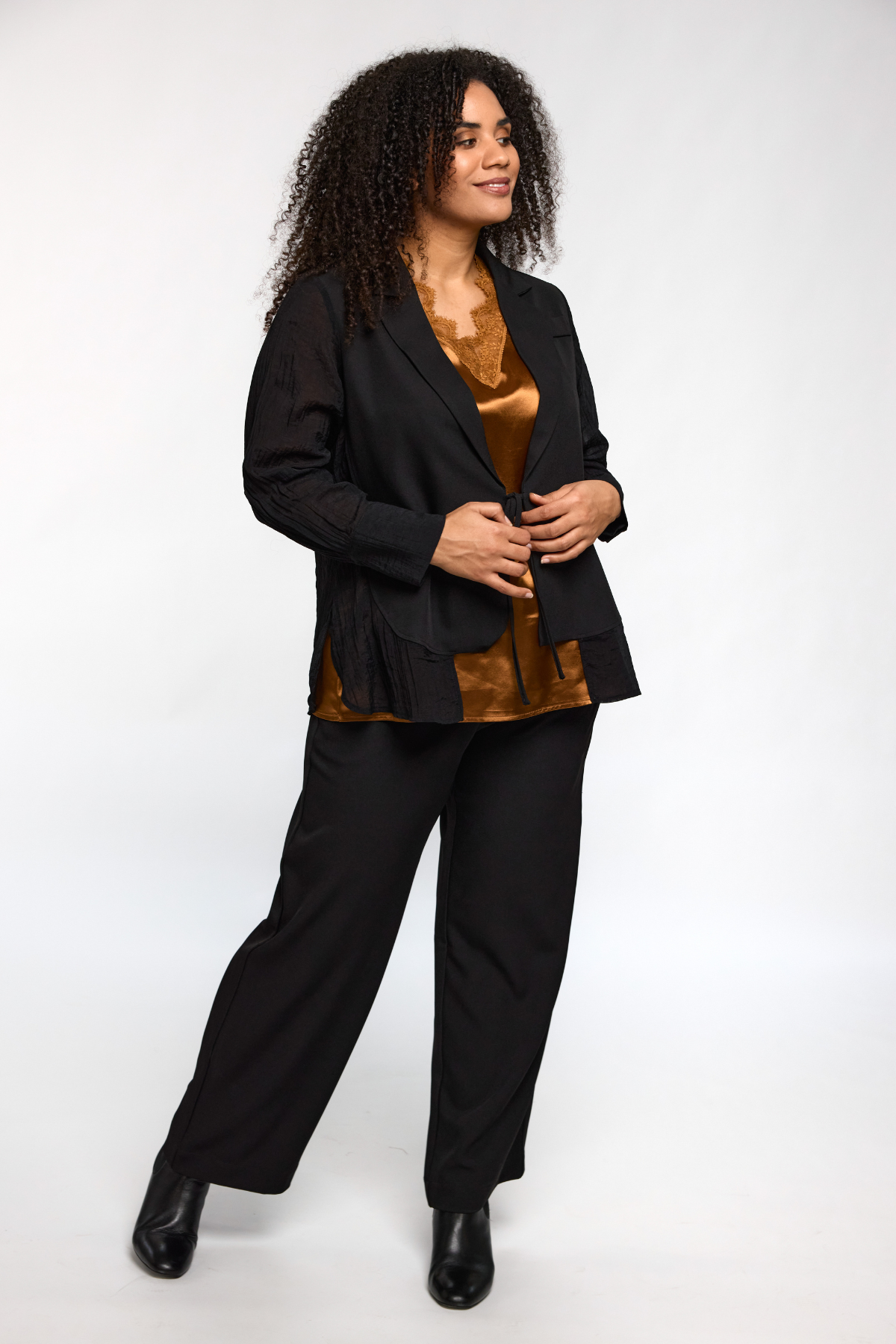 Model iført kobberfarvet Ingrid top fra STUDIO – elegant og klassisk styling.