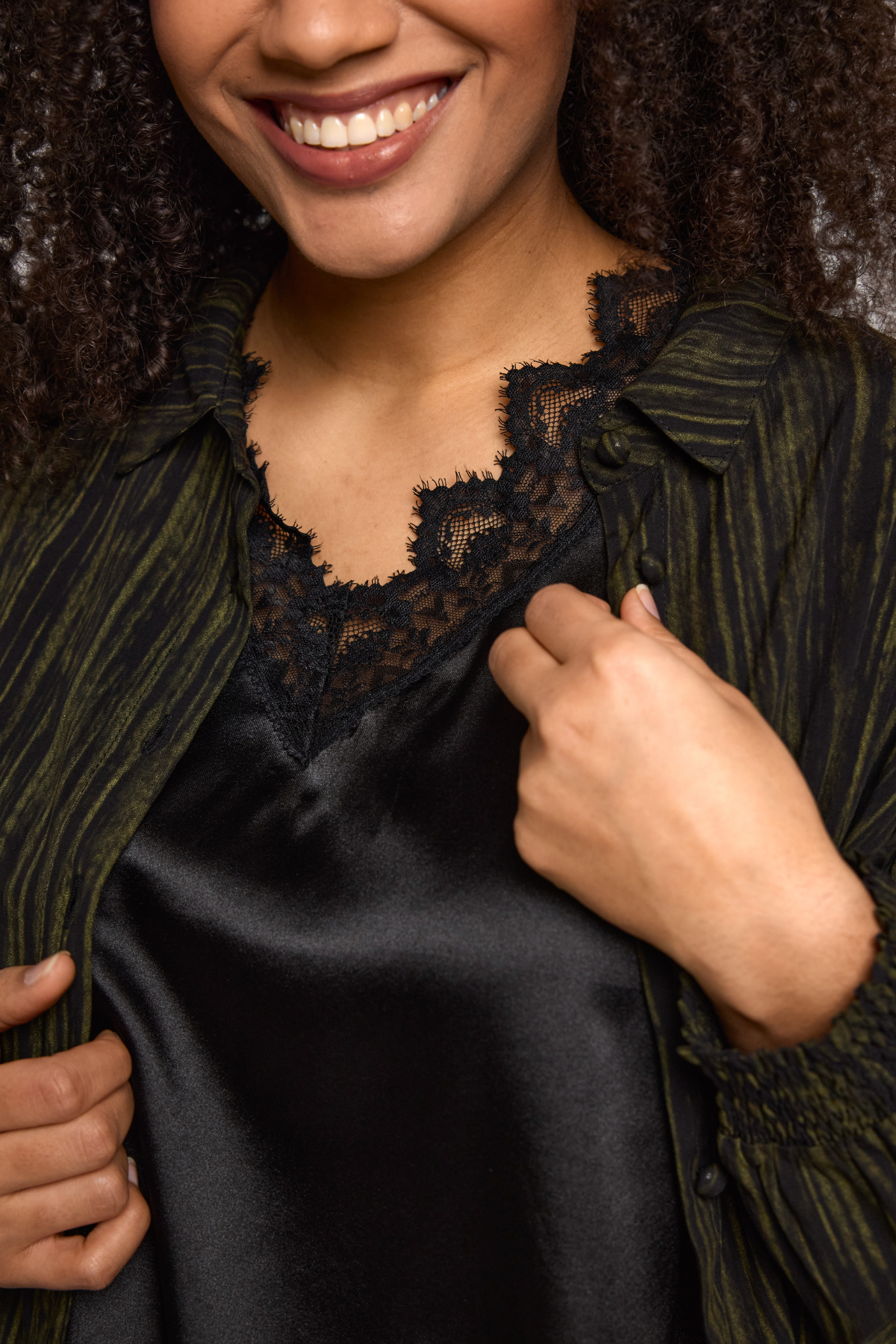 Nærbillede af blondekant og satinfinish på Ingrid top i sort fra STUDIO.