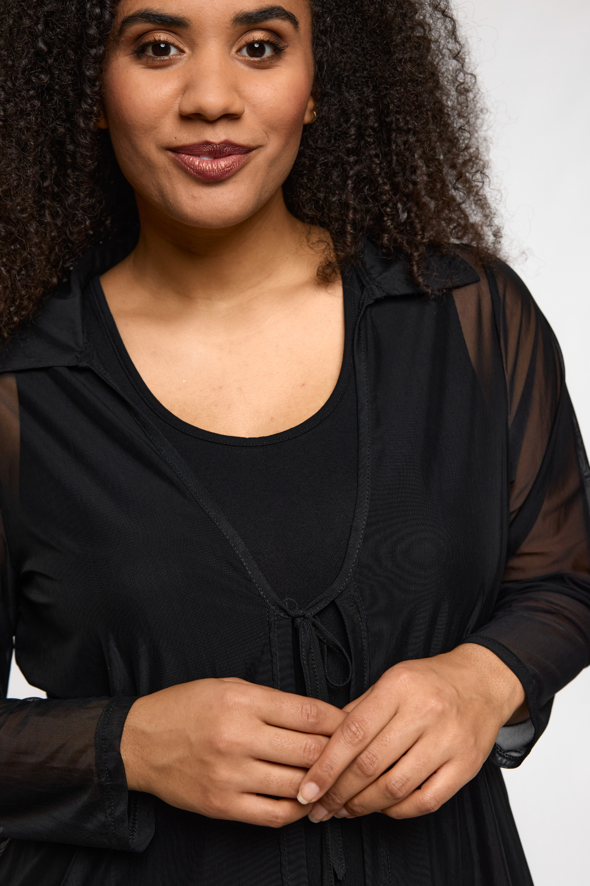 Nana Cardigan Sort fra STUDIO – model viser frontdetalje med båndlukning og meshstof.